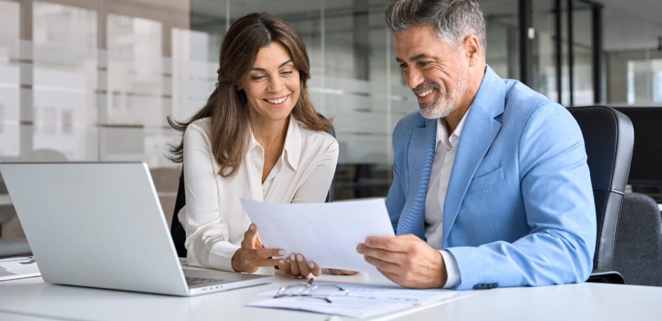 business owner and solicitor reviewing documents at computer