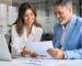business owner and solicitor reviewing documents at computer