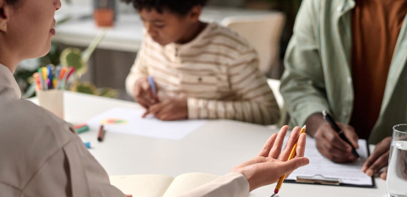 solicitor talking to parent, with child drawing in background