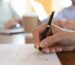 man signing contract with two other people watching